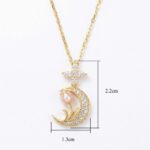 Gold-tone crescent moon pendant encrusted with crystals, featuring a pink pearl blossom and a small sparkling star on top, hanging from a gold chain (dimensions shown: about 2.2 cm tall, 1.3 cm wide).