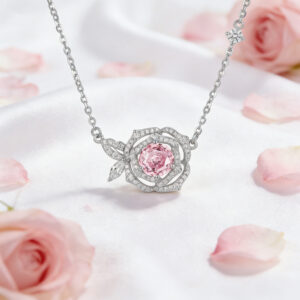 Silver necklace with a rose-shaped pendant featuring a pink gemstone center and surrounding small diamonds on a satin background with pink petals.